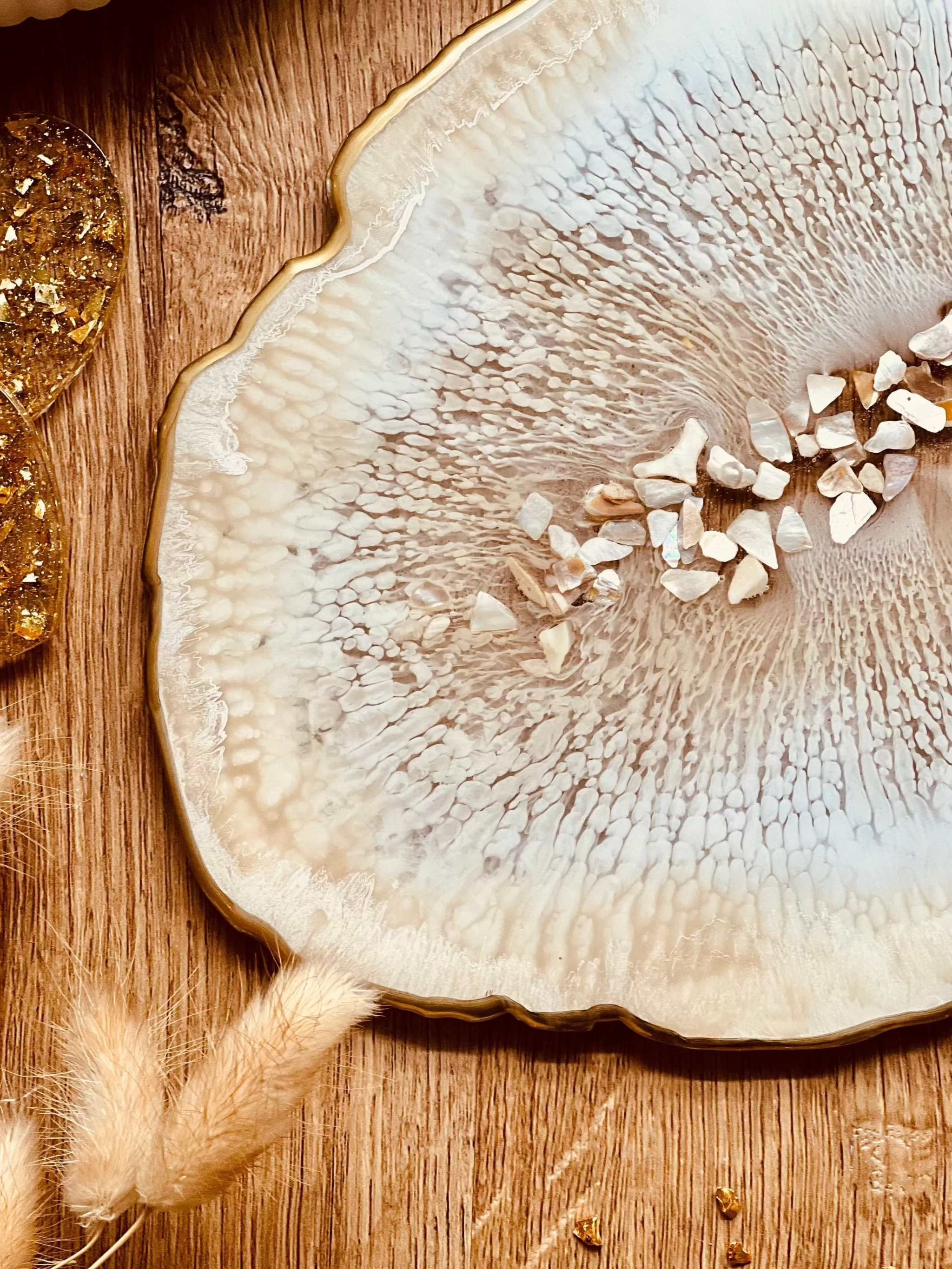 Beiges handgemachtes Tablett aus Resin mit goldenen Details und Perlmutt auf Holztisch