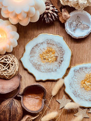 Detailreiche weiße Resin Untersetzer mit goldenen Akzenten im 2er Set auf Holztisch dekoriert