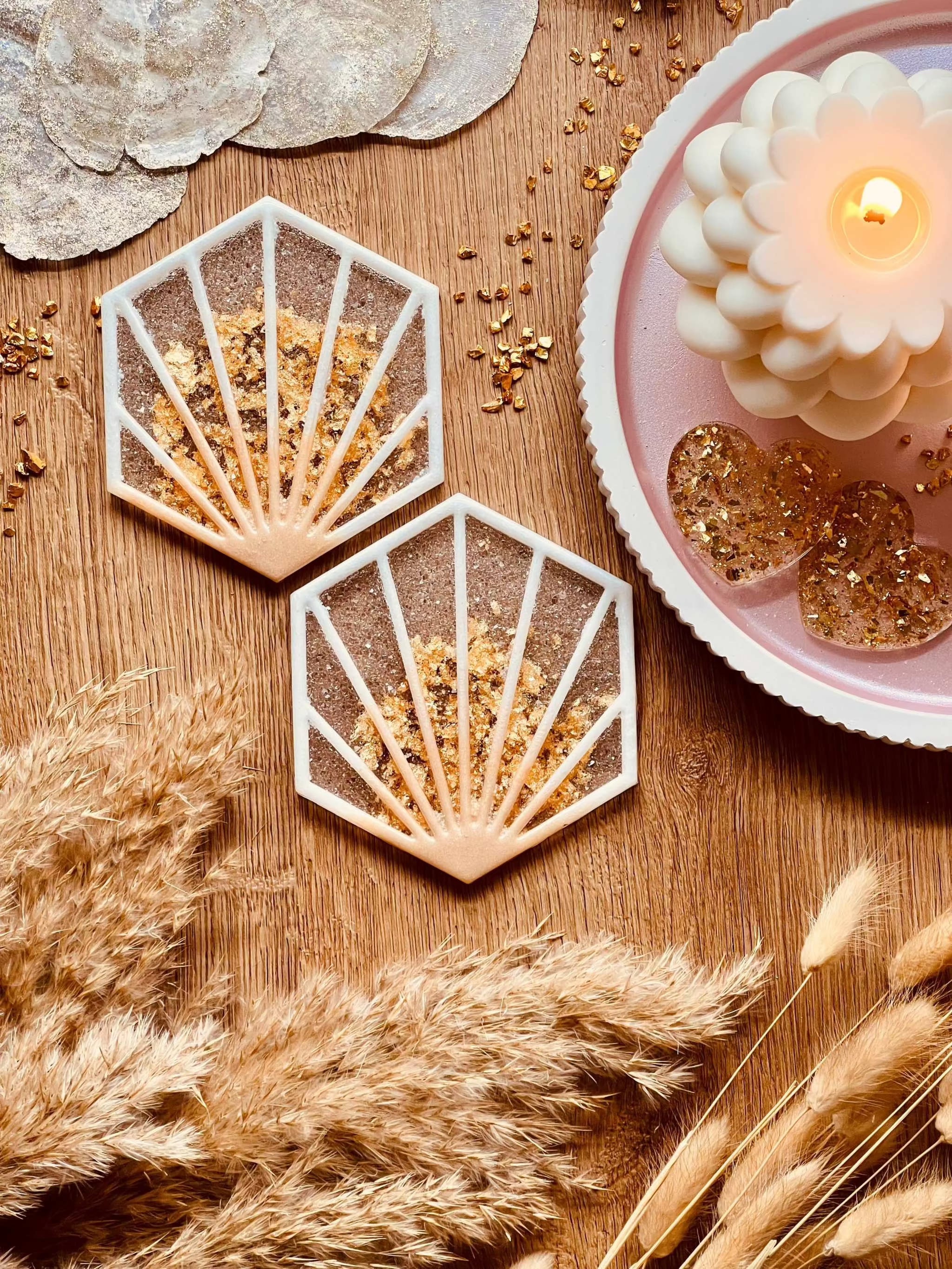 2 außergewöhnliche handgemachte Untersetzer aus weißem Resin mit goldenen Details auf Holztisch dekorativ platziert