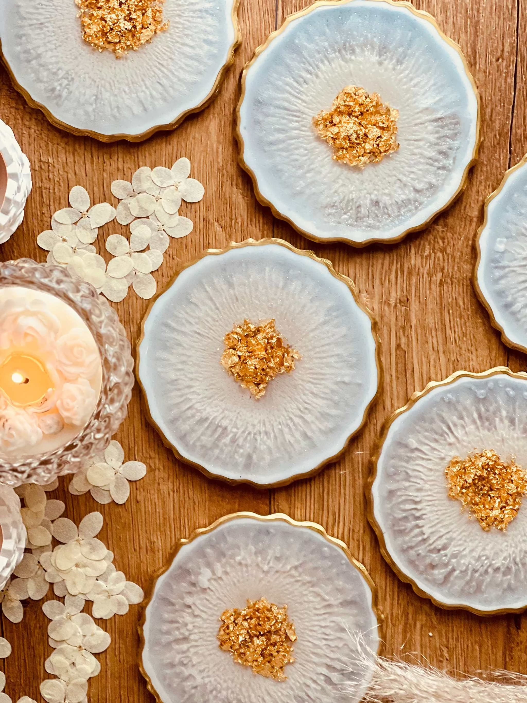7 klassische Untersetzer aus weissem Resin mit goldenen Details handgemacht auf Holztisch