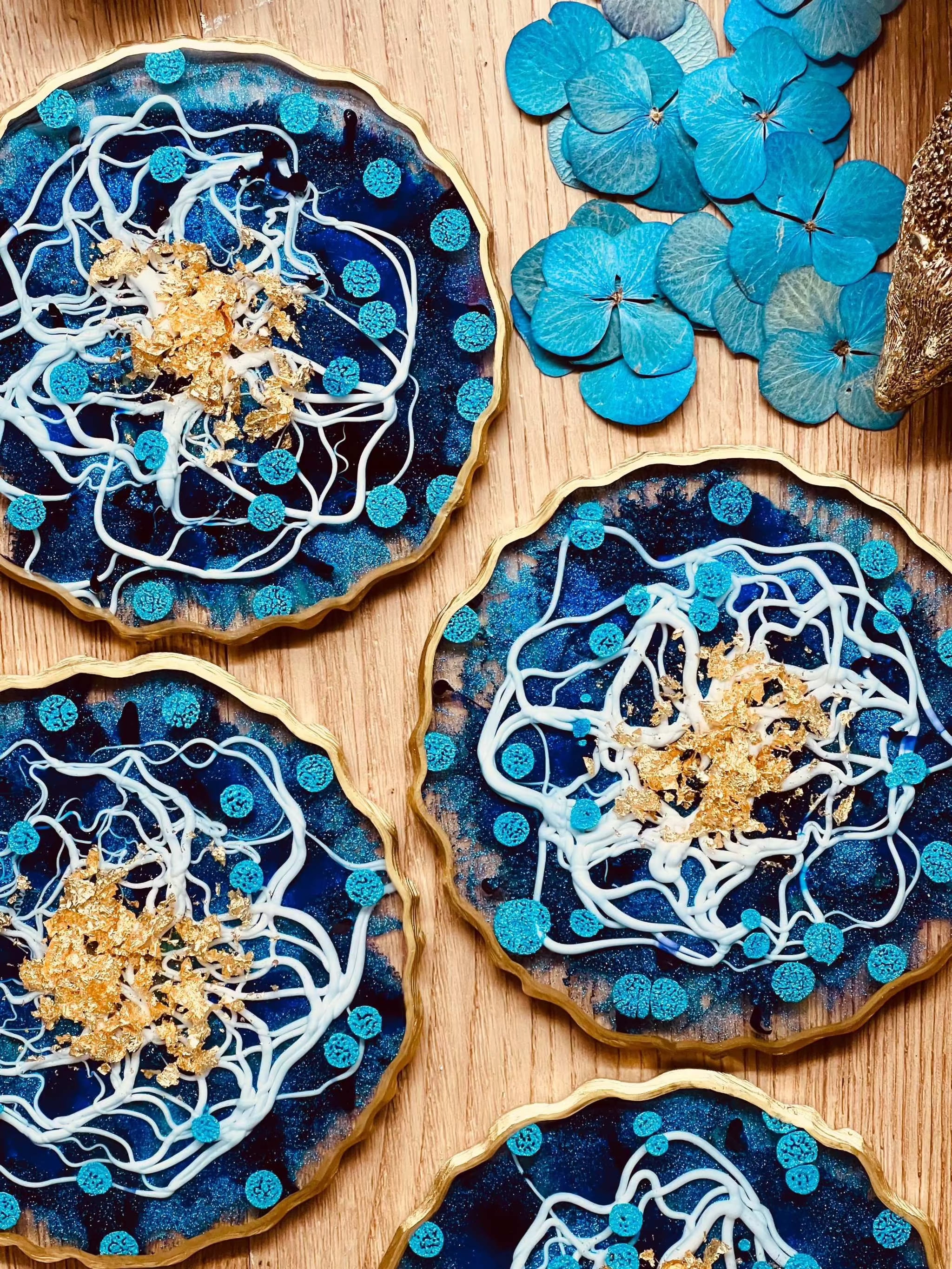 4 Untersetzer aus Resin in Blau-Weiß mit goldenen Details handgemacht und einzigartig auf Holztisch