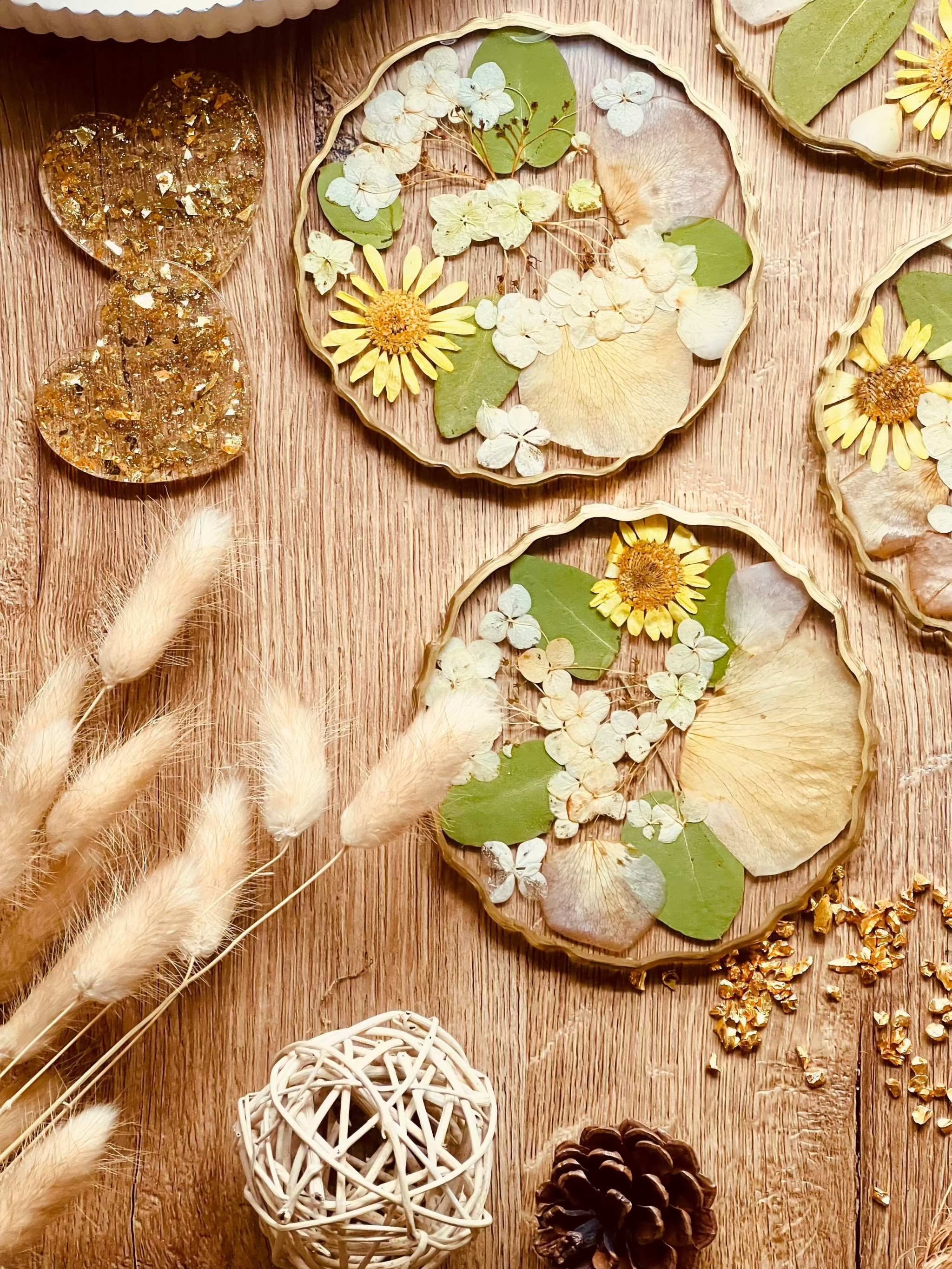 4 Untersetzer aus Resin mit echten Hortensien, Blumen und goldenen Details auf Holztisch