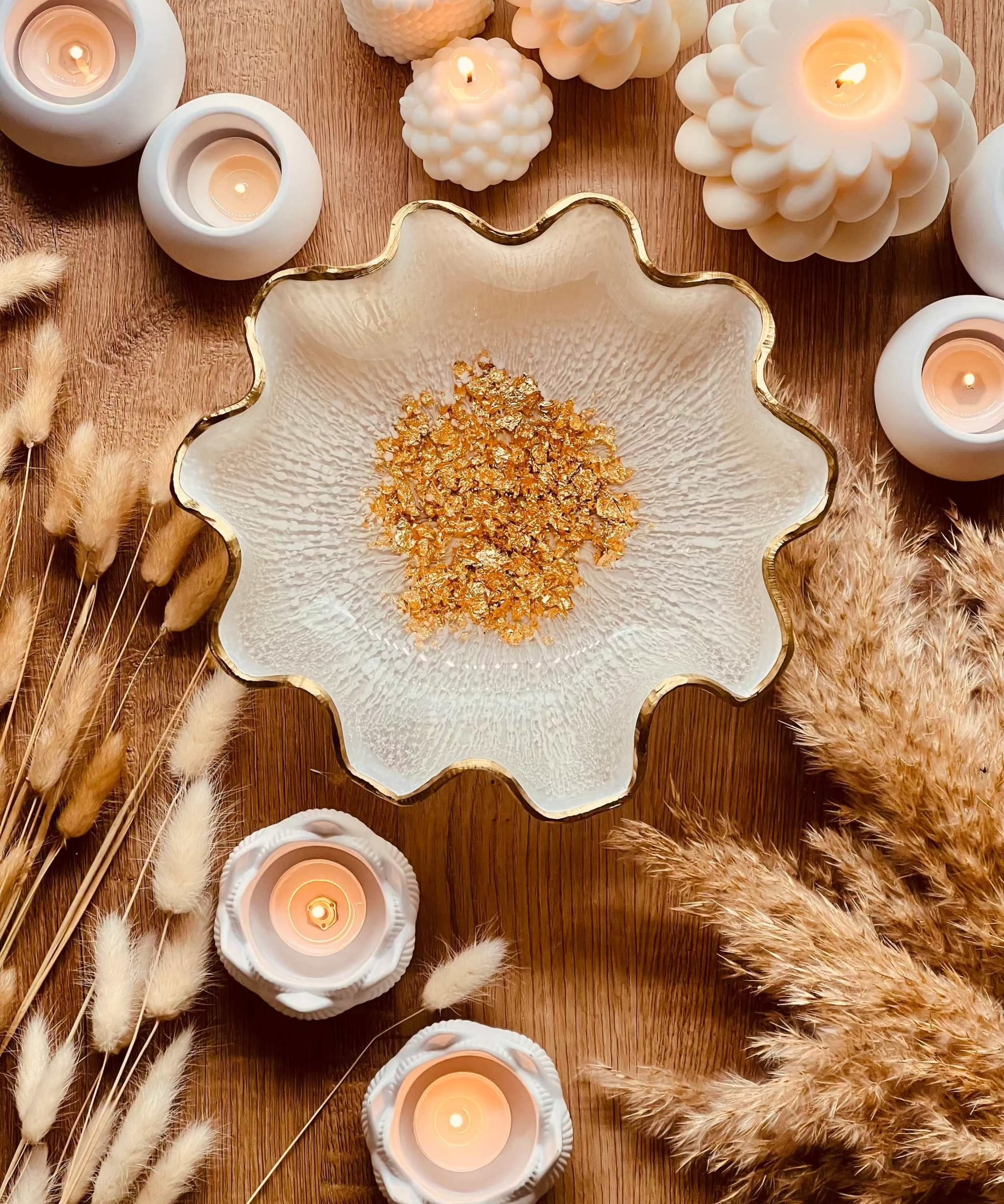 handgemachte weiße Schale aus Resin mit goldenen Details und wellenförmigem Rand, dekoriert mit Kerzen und Trockenblumen