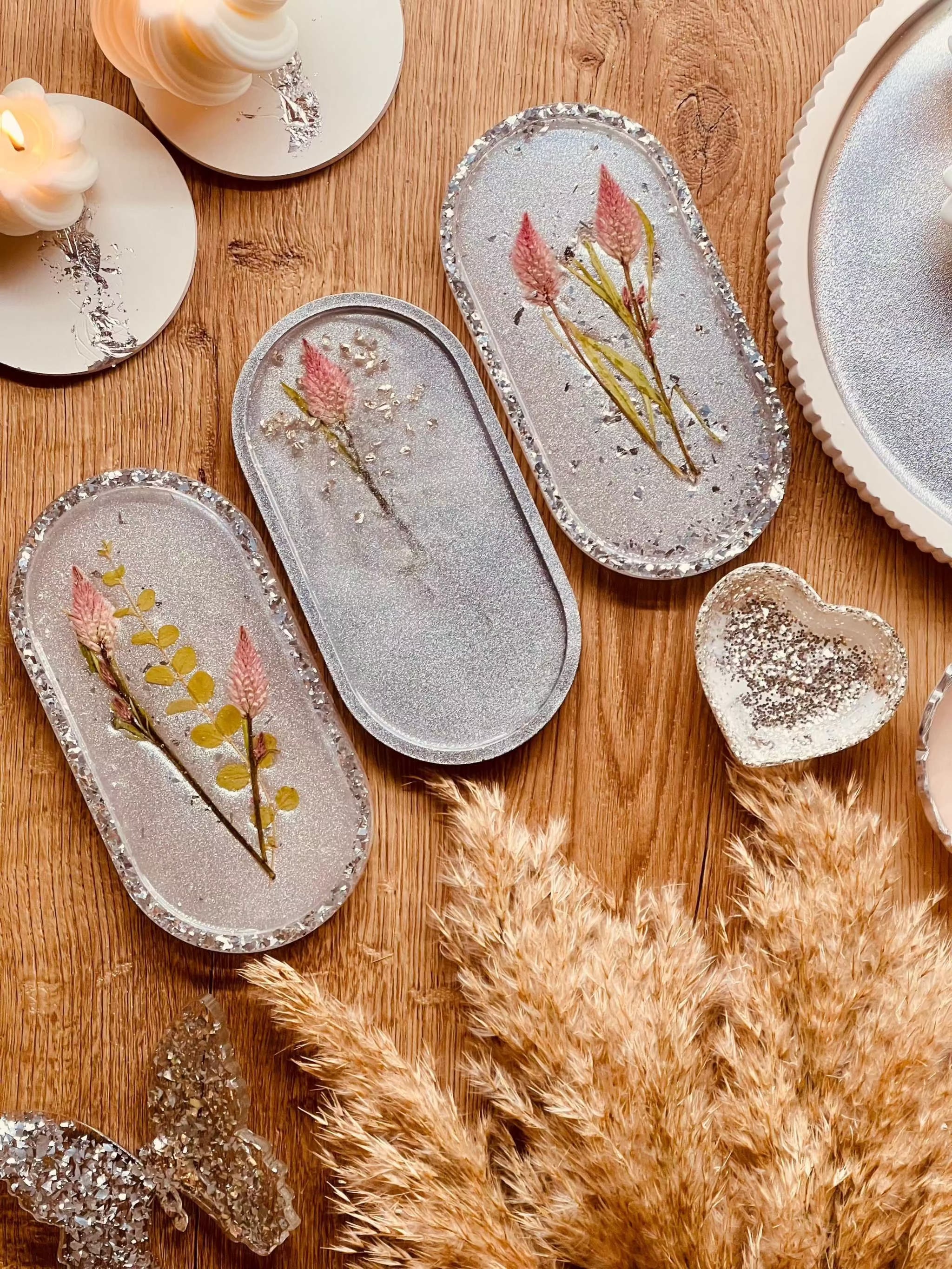 Schmuckschalen aus Resin in Weiß mit Silberrand und eingearbeiteten getrockneten Blumen auf Holztisch