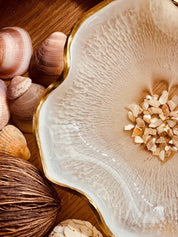 Weiße handgemachte Schale aus Resin mit Perlmutt und Goldrand, dekorativ auf Holz mit Muscheln arrangiert