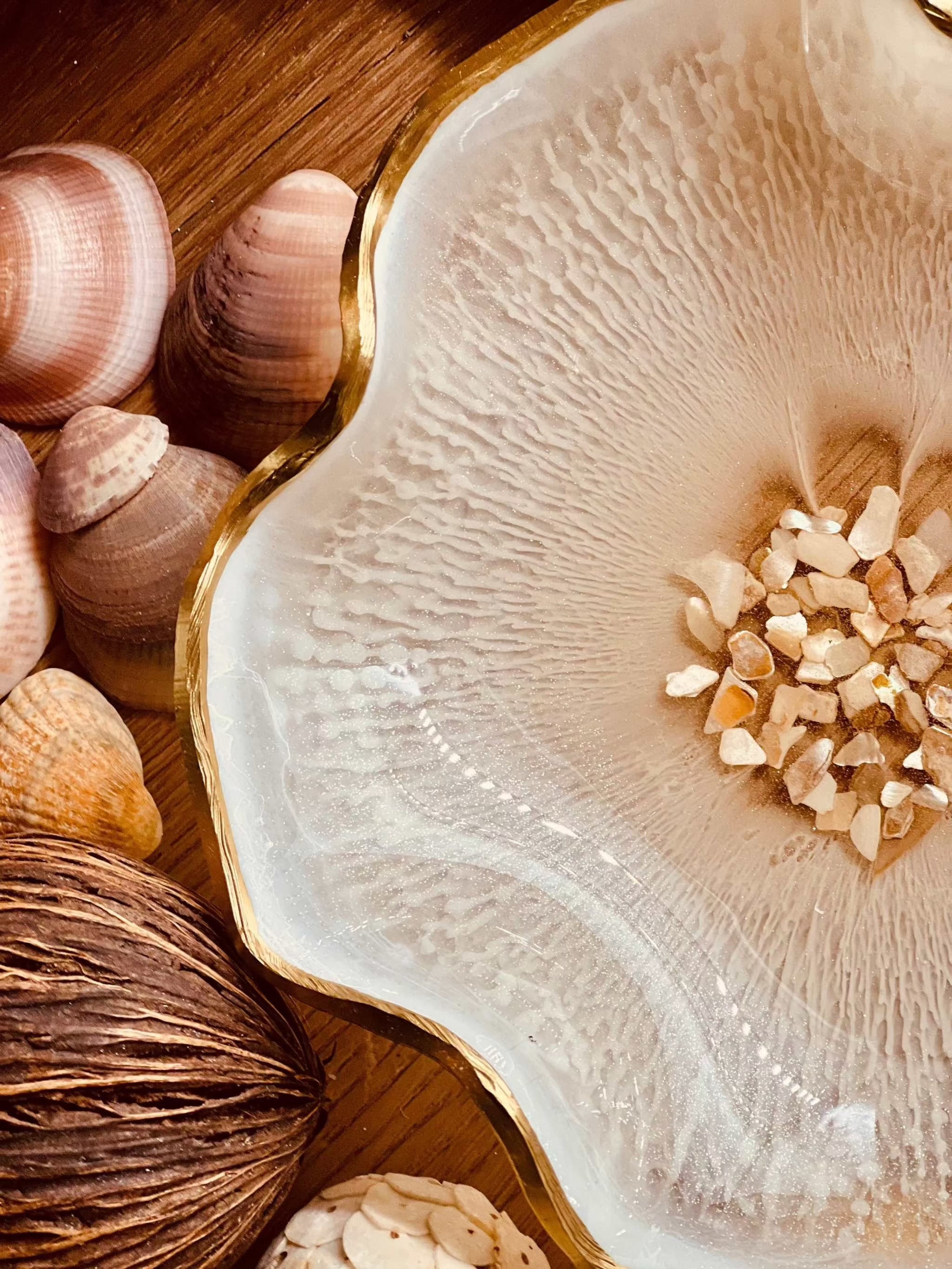 Weiße handgemachte Schale aus Resin mit Perlmutt und Goldrand, dekorativ auf Holz mit Muscheln arrangiert