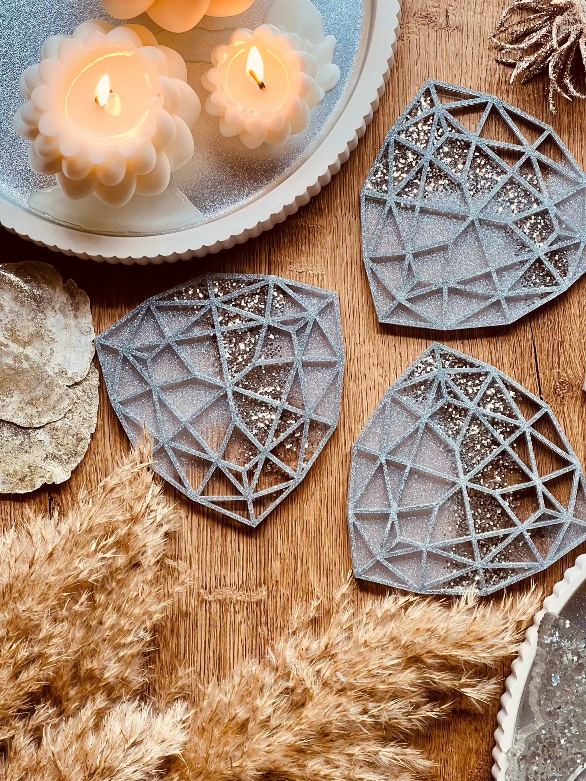 Vier weiße Resin Untersetzer mit silbernen geometrischen Details handgemacht auf Holztisch mit Dekoration