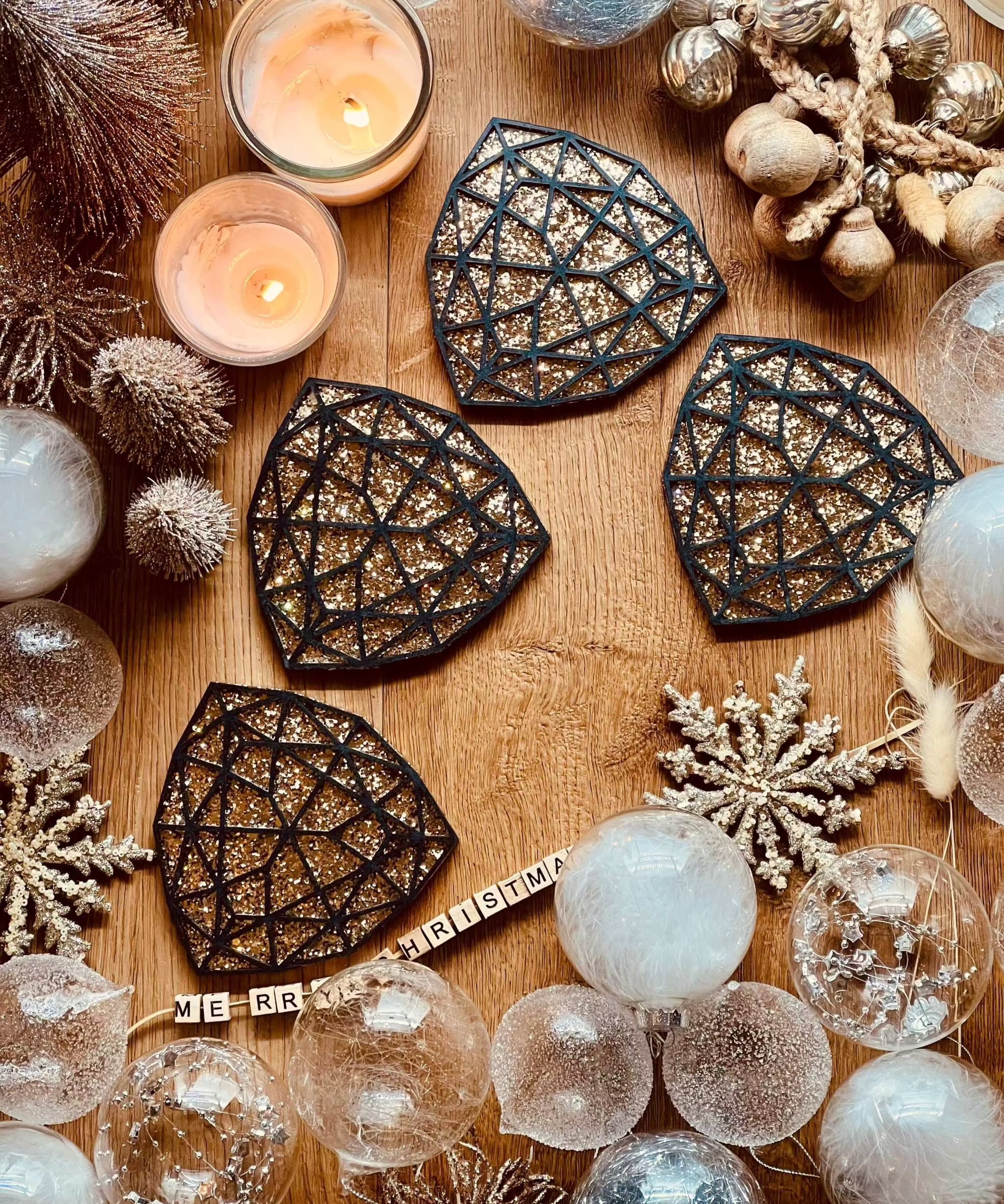 Schwarze handgemachte Untersetzer aus Resin mit goldenen 3D-Details im 4er Set auf Holztisch mit Weihnachtsdekoration
