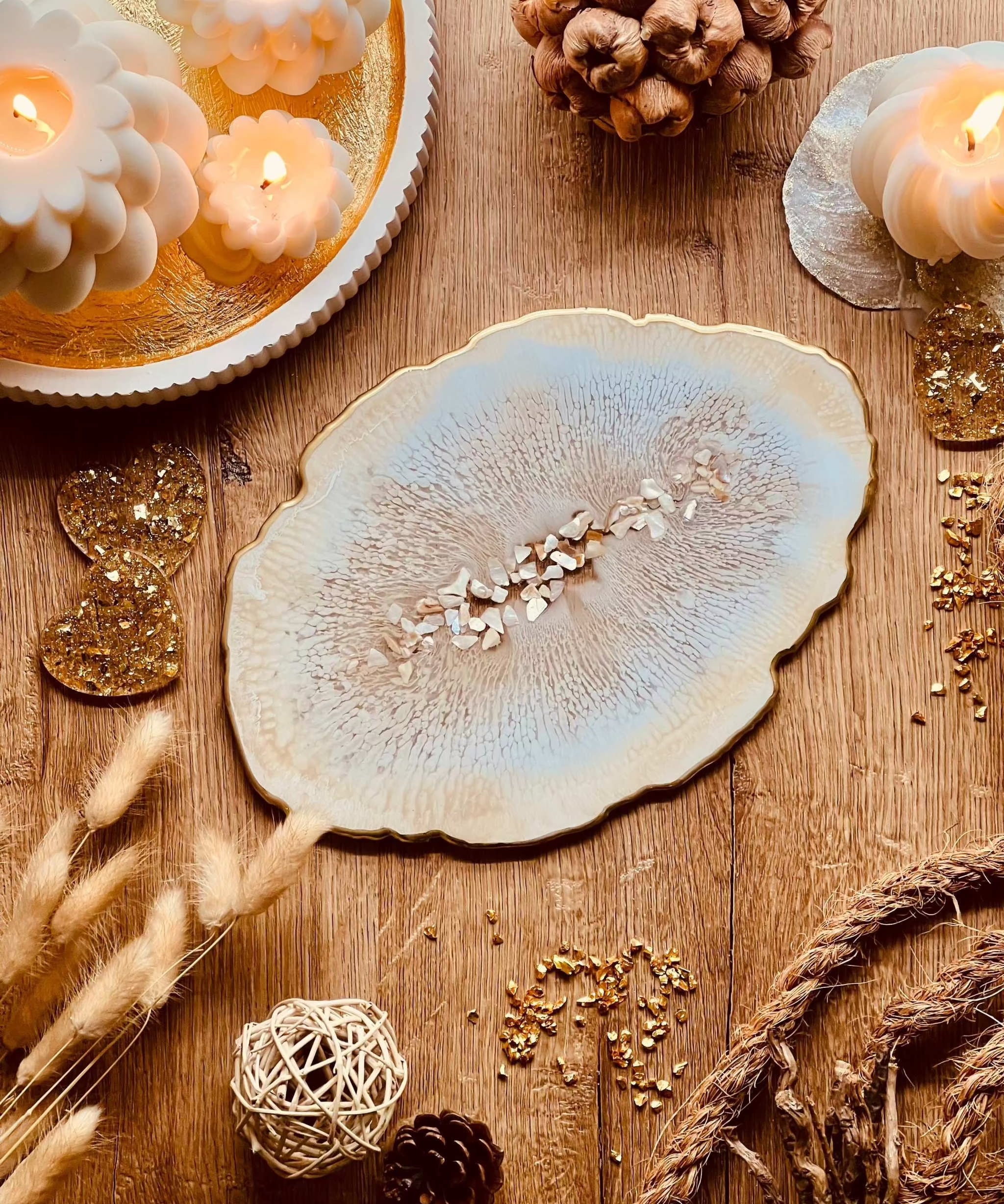 Beiges handgemachtes Tablett aus Resin mit goldenen Details und Perlmuttstücken auf Holzoberfläche dekorativ arrangiert
