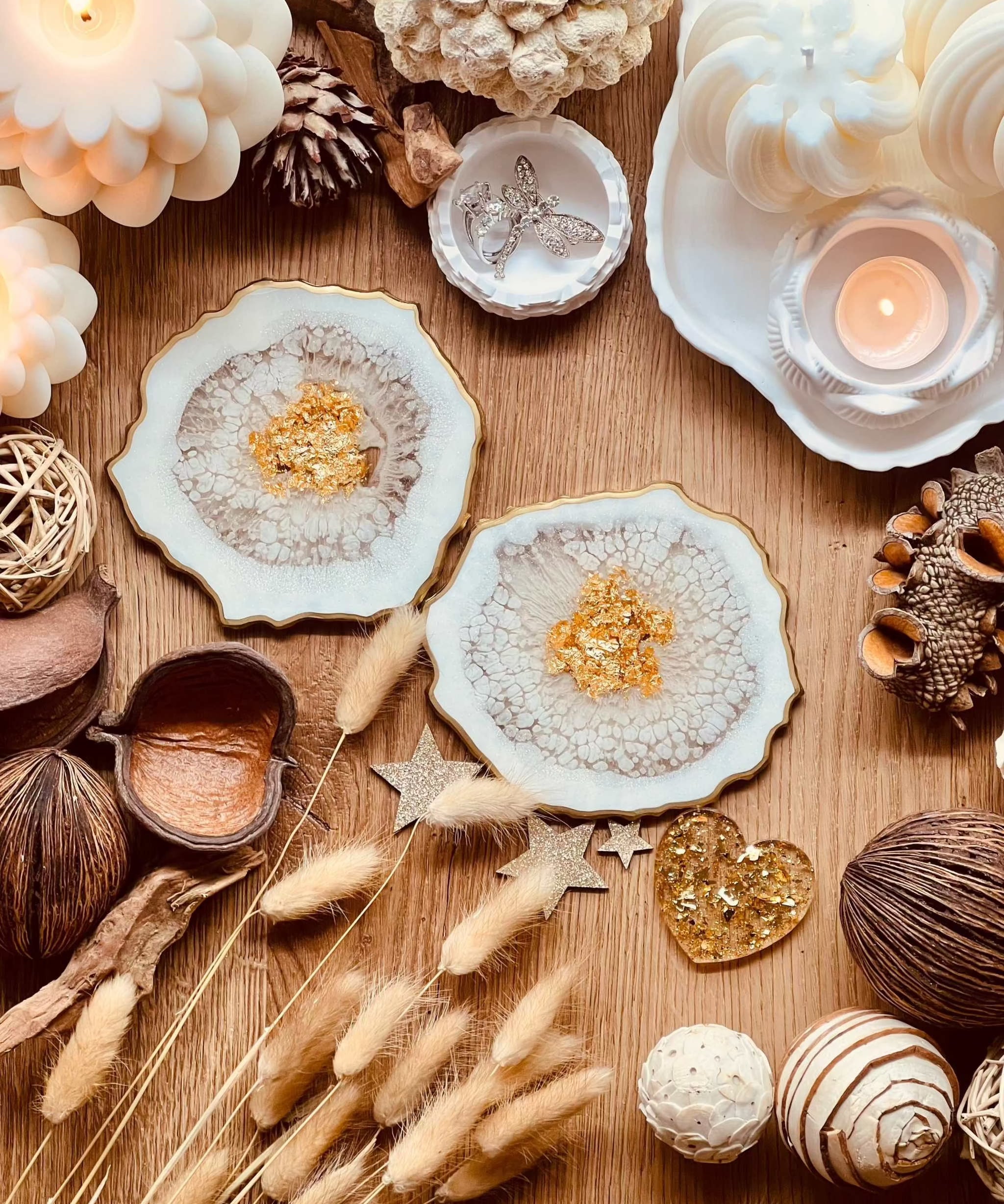 Zwei detailreiche weiße Resin-Untersetzer mit goldenen Akzenten auf Holztisch dekoriert