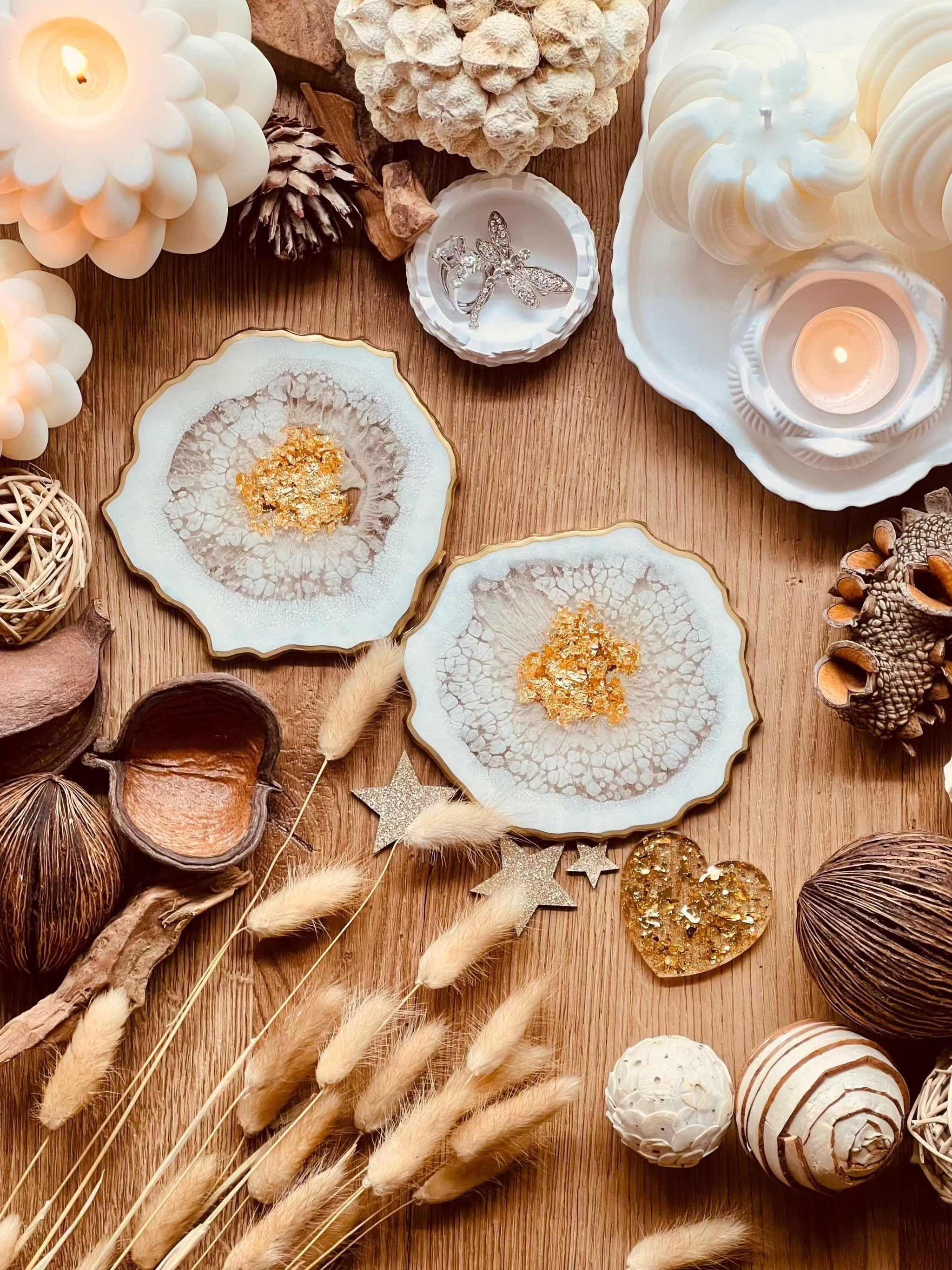 Zwei detailreiche weiße Resin-Untersetzer mit goldenen Akzenten auf Holztisch dekoriert