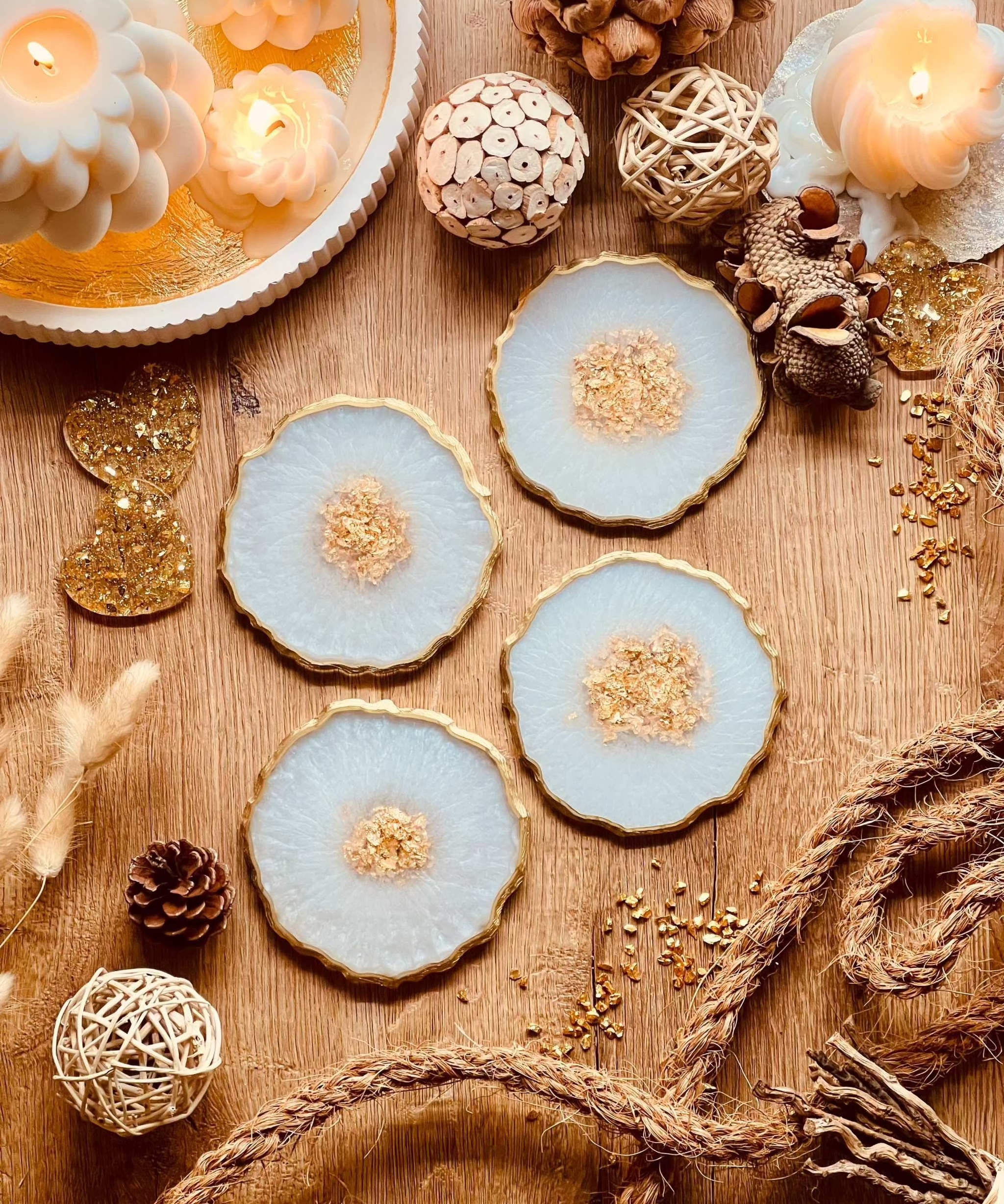 4 handgemachte Untersetzer aus Resin in weiss mit goldenen Details auf Holztisch dekoriert