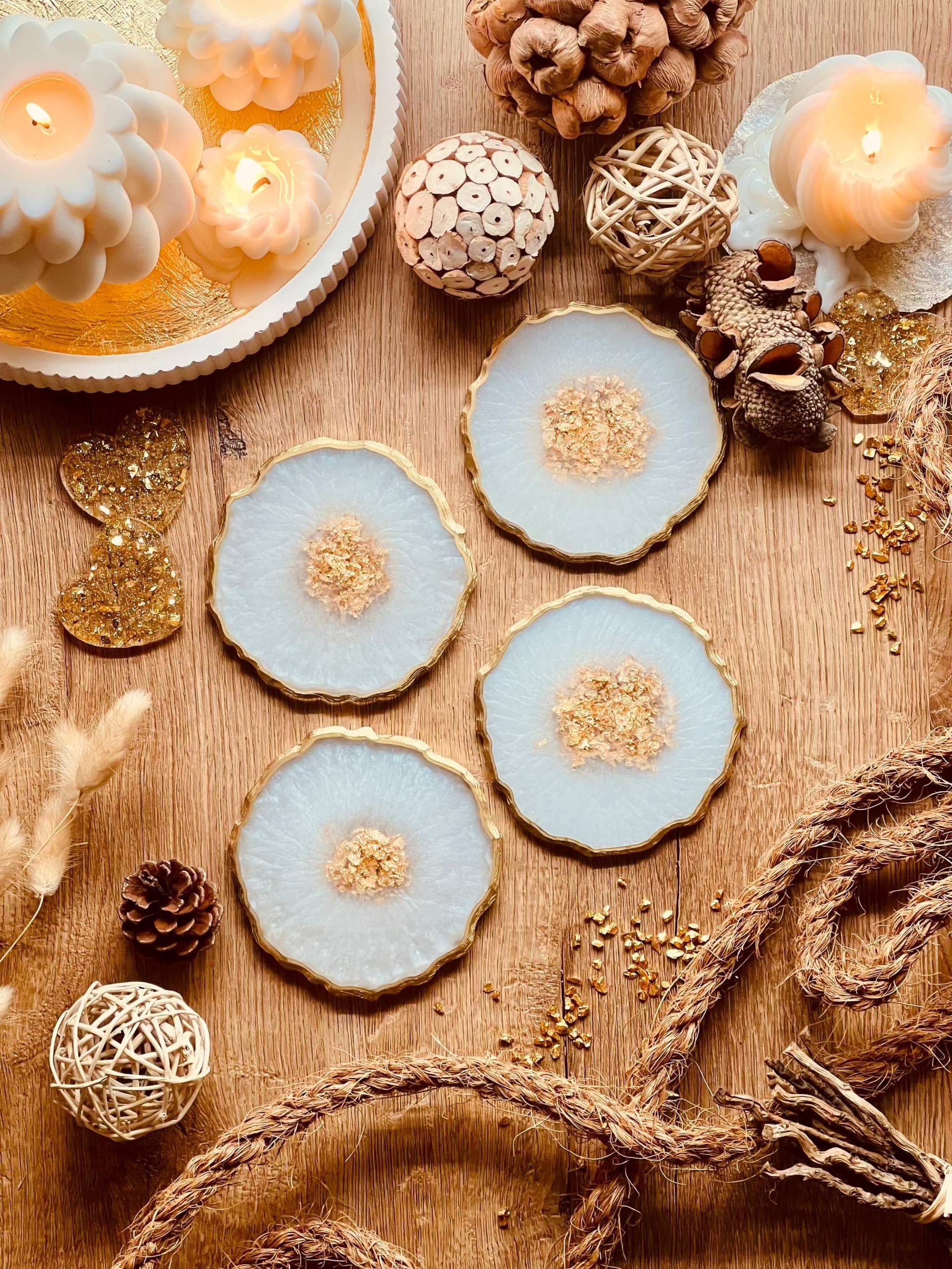 4 handgemachte Untersetzer aus Resin in weiss mit goldenen Details auf Holztisch dekoriert