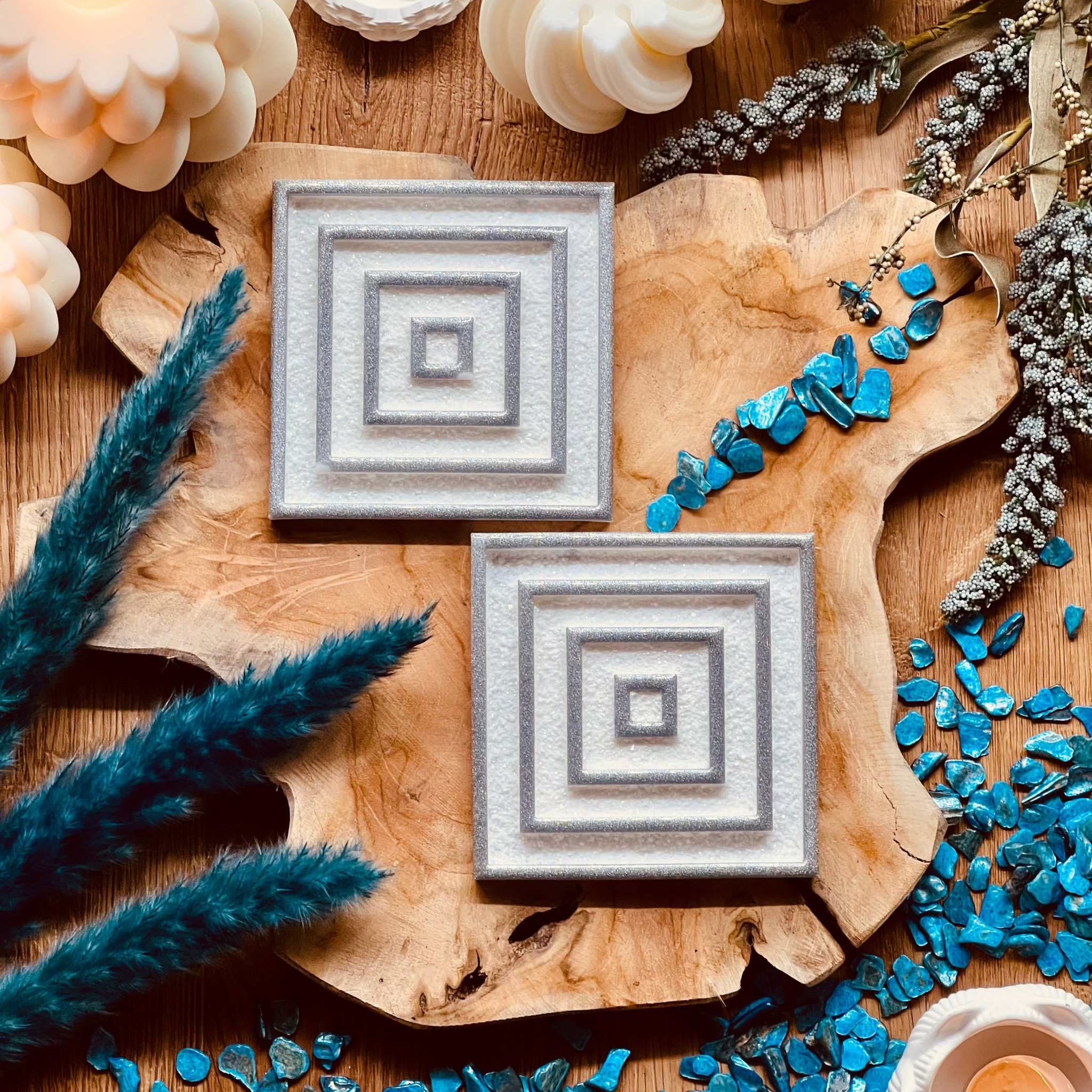 2 white resin coasters with silver 3D design