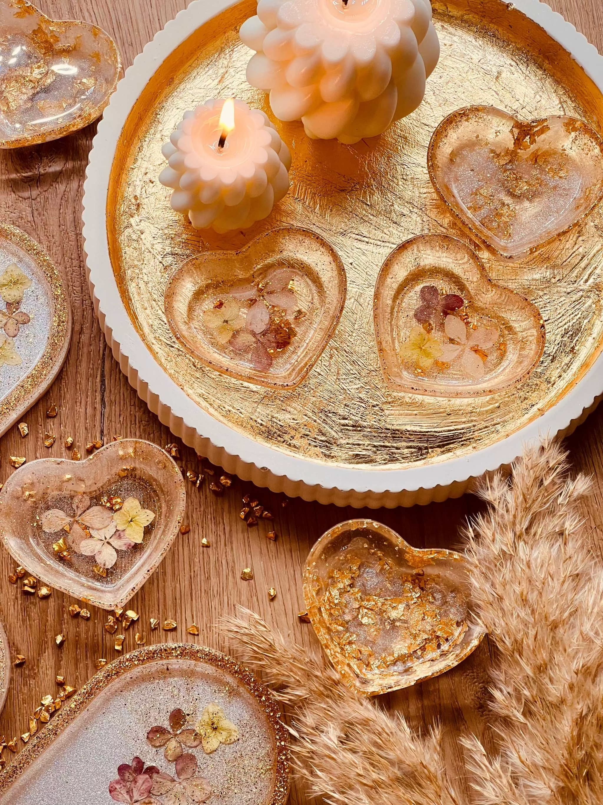 Weiße handgemachte Schmuckschalen aus Resin mit goldenen Akzenten und getrockneten Blumen in Herzform als dekorative Unikate