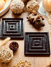 2 handgemachte schwarze Untersetzer aus Resin mit 3D Design auf Holztisch
