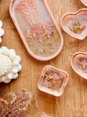 Handgemachte Schmuckschalen aus Resin in Korall mit Gold und getrockneten Rhododendron Blüten, verschiedene Formen auf Holztisch